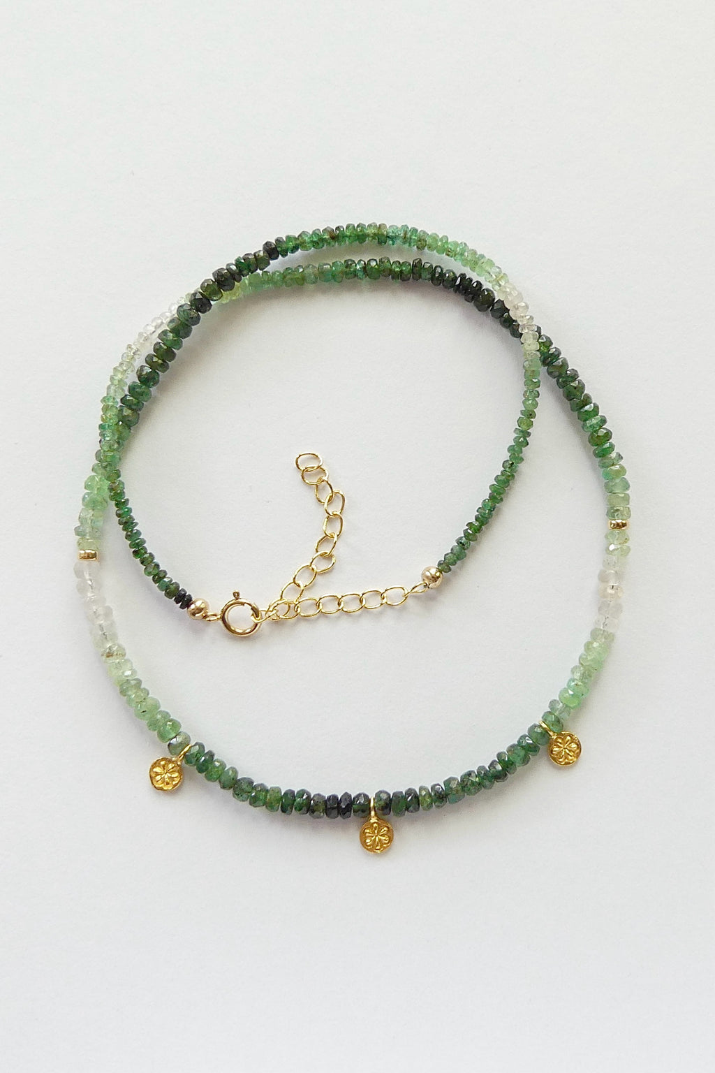 Dainty ombré emerald necklace with faceted green gemstone beads, gold vermeil daisy charms, and adjustable gold-filled clasp, 16 to 18 inches long