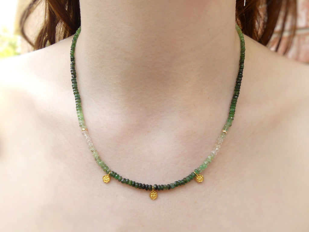 Dainty ombré emerald necklace with faceted green gemstone beads, gold vermeil daisy charms, and adjustable gold-filled clasp, 16 to 18 inches long