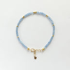 Vivid Blue aquamarine dainty beaded bracelet with gold accents on a light gray background