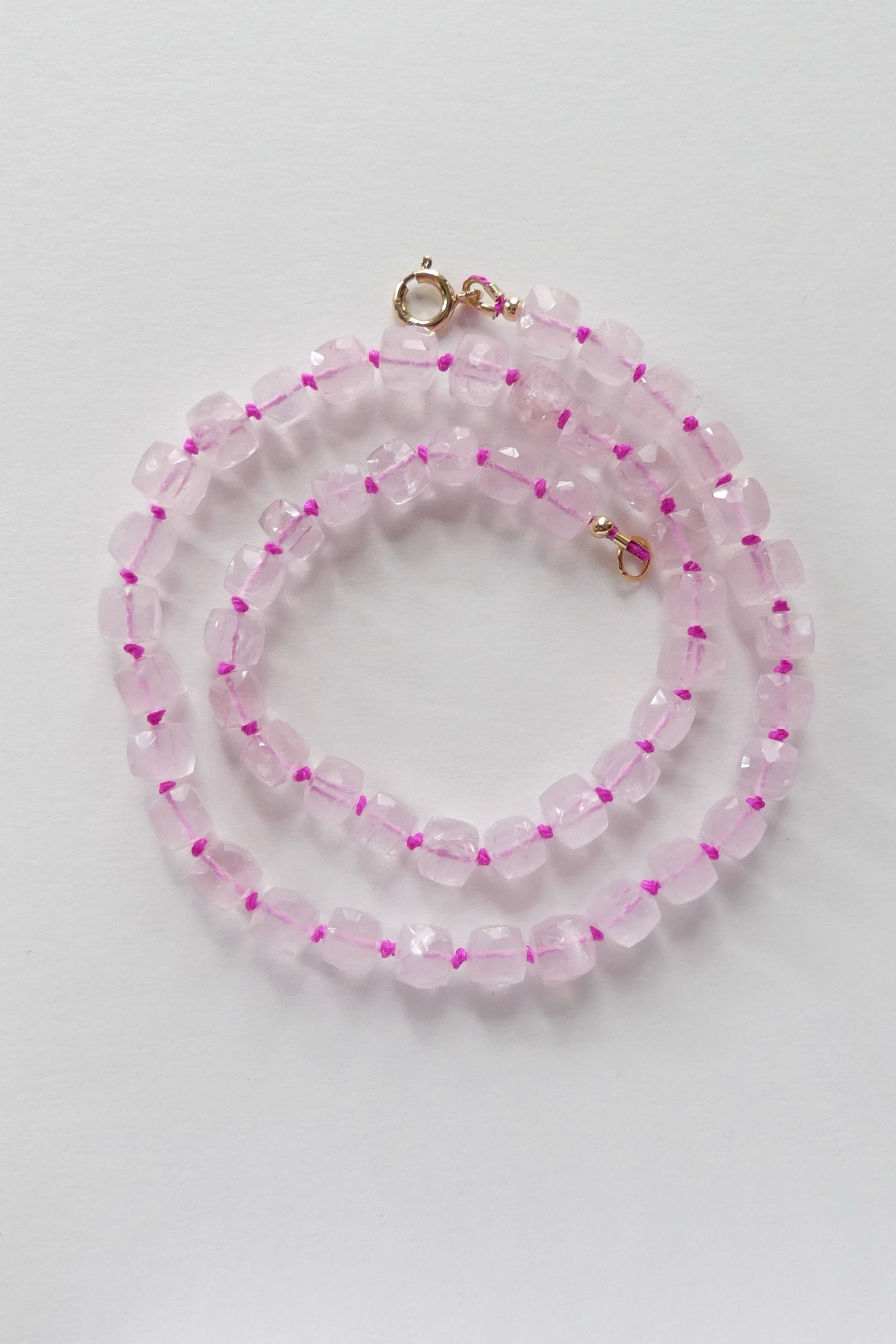 18.5" rose quartz necklace made with faceted cube beads, hand-knotted on pink silk and finished with a gold-filled clasp