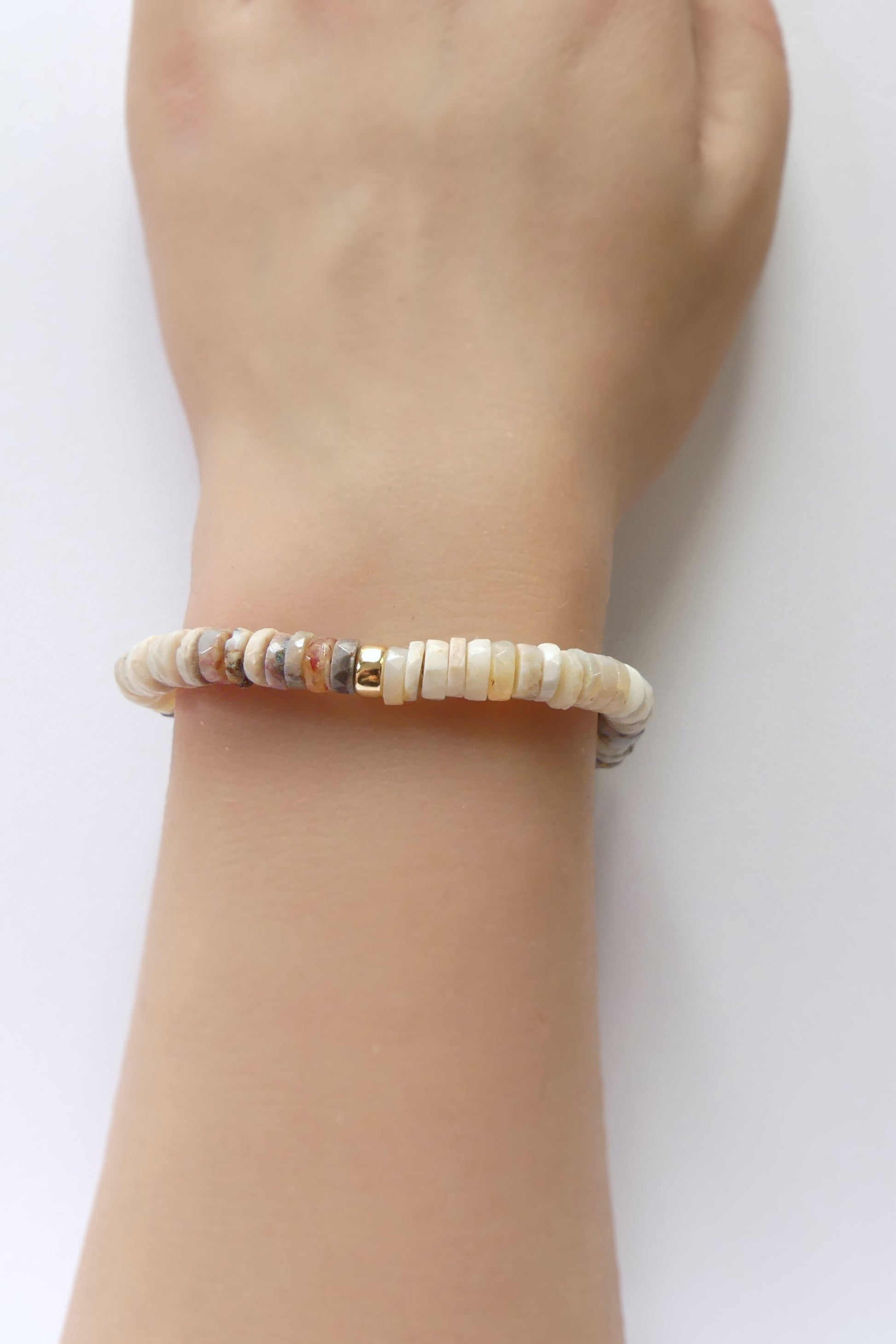 Stretch bracelet with natural Australian opal 6mm heishi beads and a gold-filled accent, shown coiled flat on a white background

