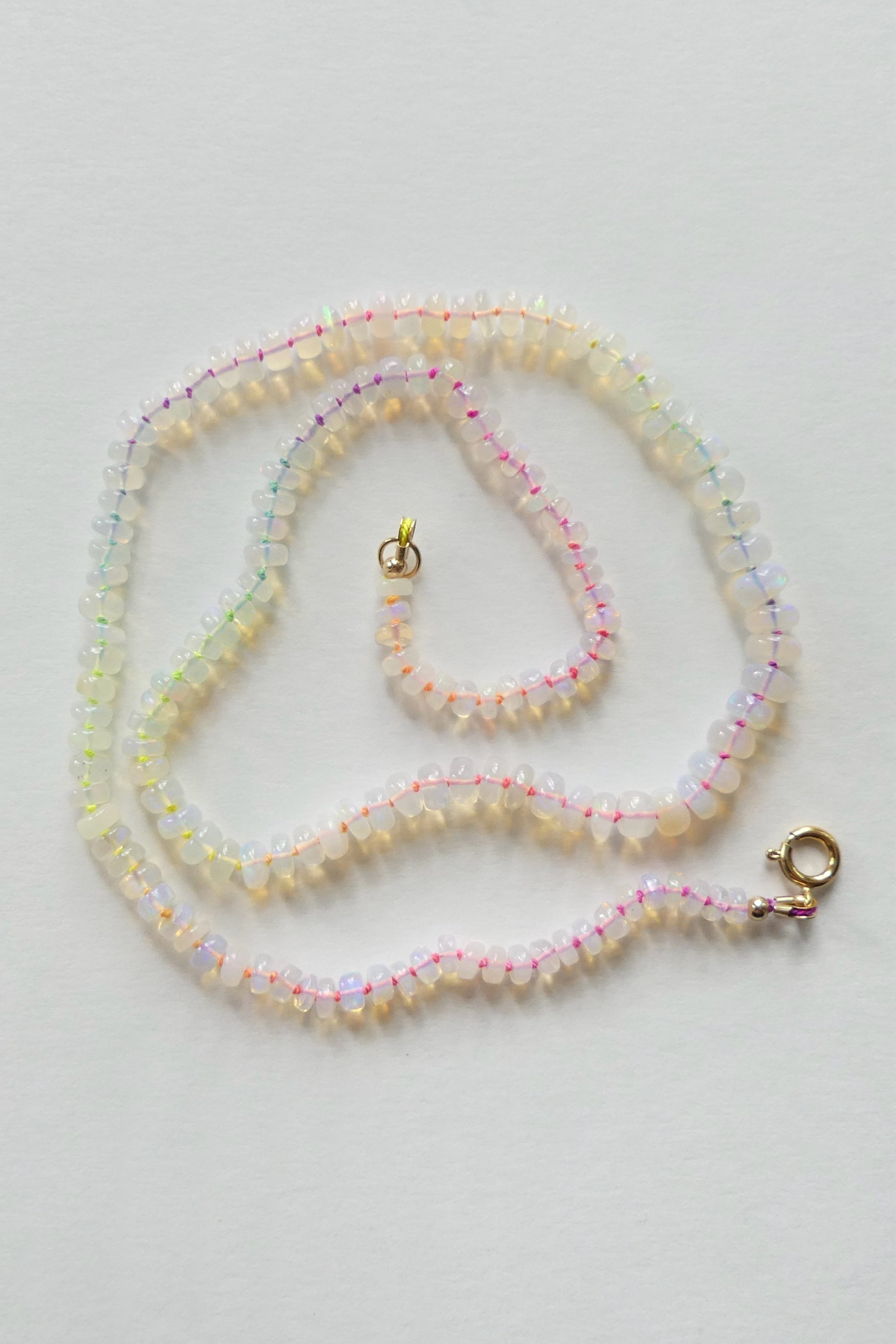 Ethiopian opal necklace with 5–7mm rondelles hand-knotted on neon rainbow silk, finished with a gold-filled clasp

