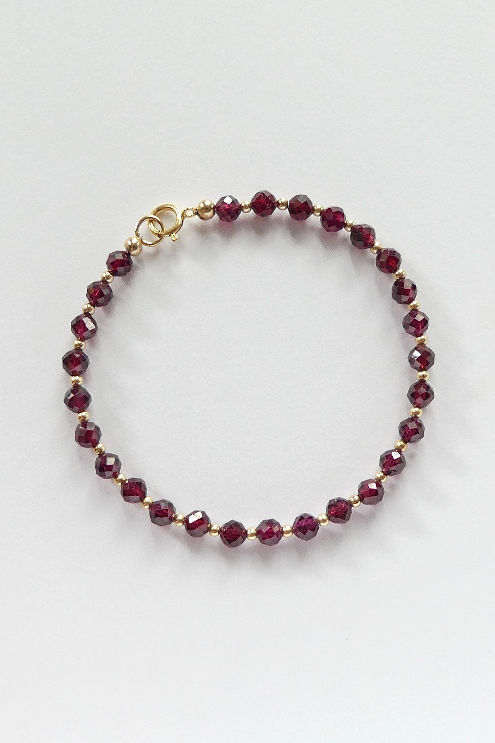 Red pyrope garnet bracelet made with 4mm faceted beads and 14k gold-filled clasp and accent spacers