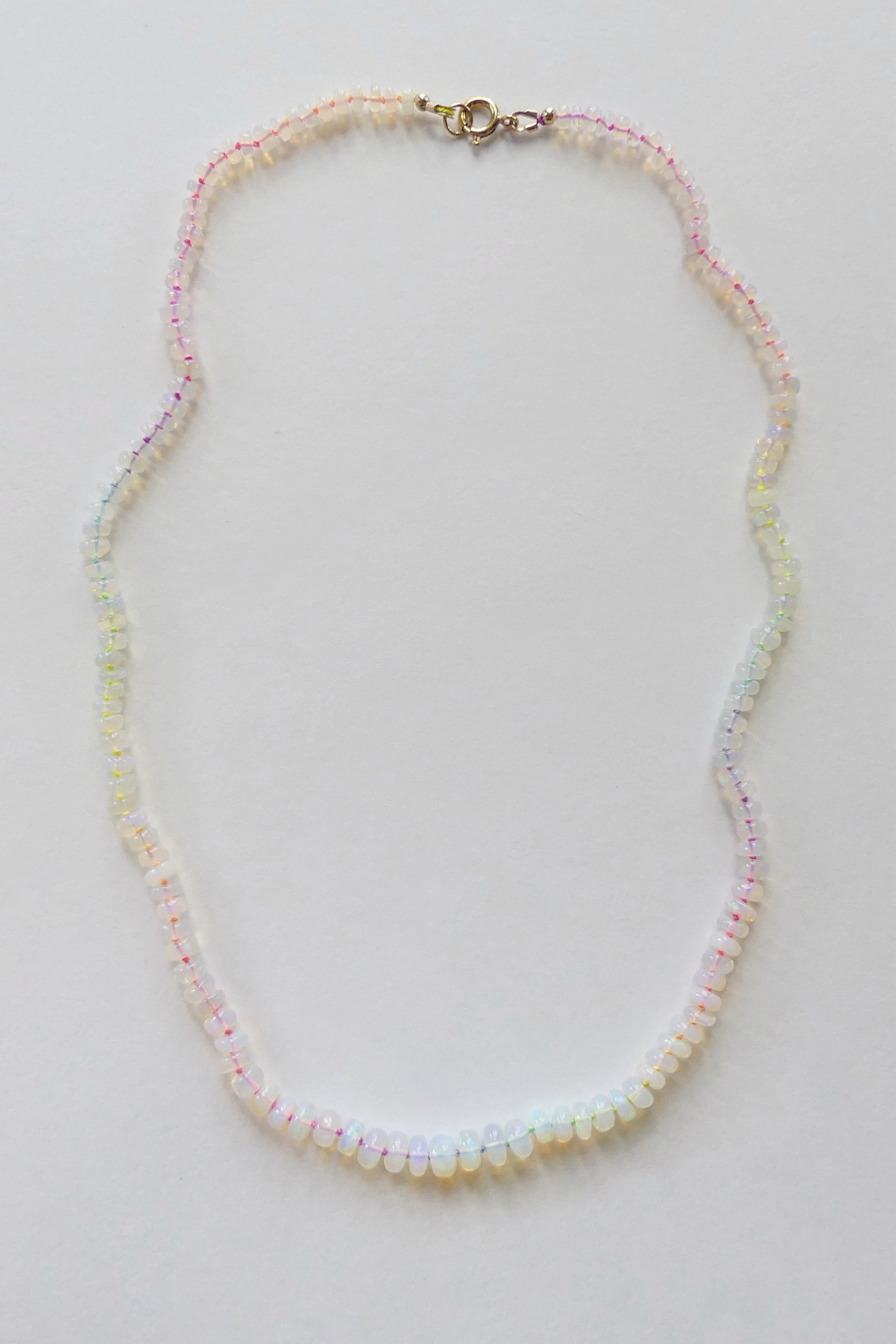 Ethiopian opal necklace with 5–7mm rondelles hand-knotted on neon rainbow silk, finished with a gold-filled clasp

