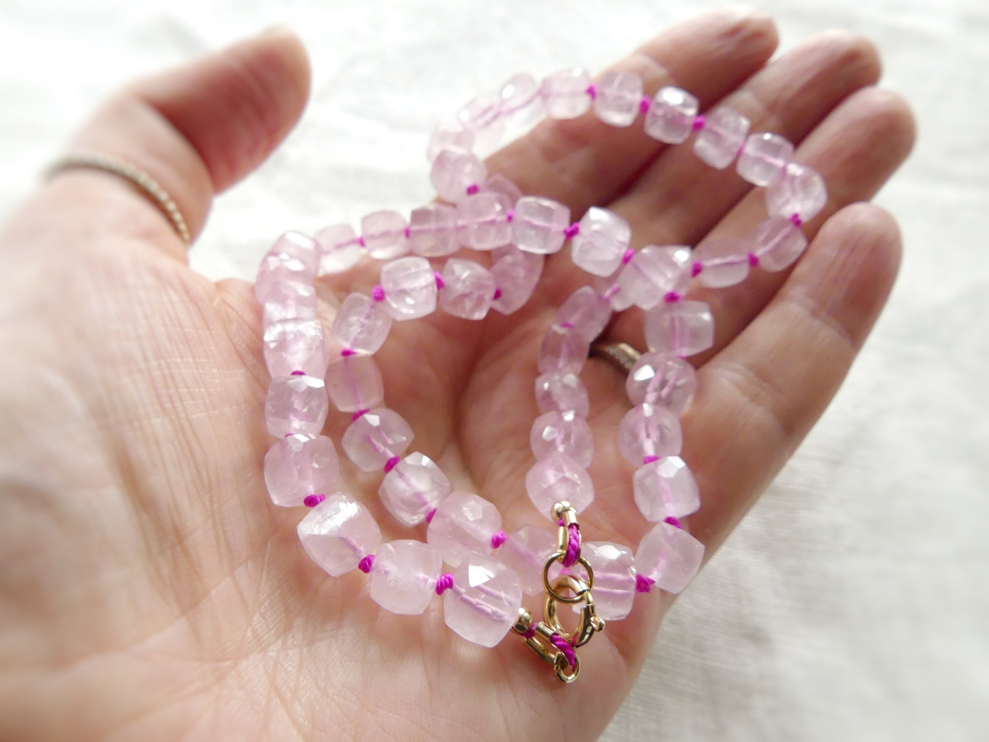 18.5" rose quartz necklace made with faceted cube beads, hand-knotted on pink silk and finished with a gold-filled clasp
