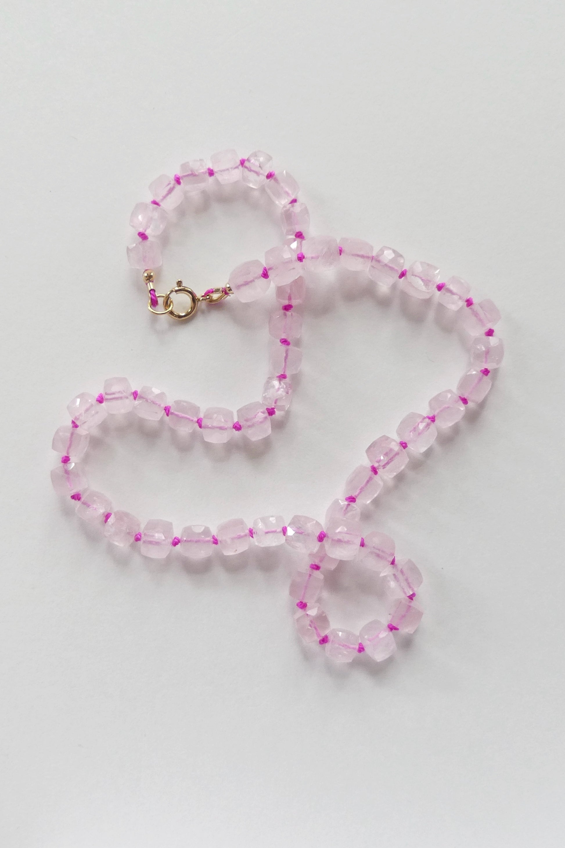 18.5" rose quartz necklace made with faceted cube beads, hand-knotted on pink silk and finished with a gold-filled clasp