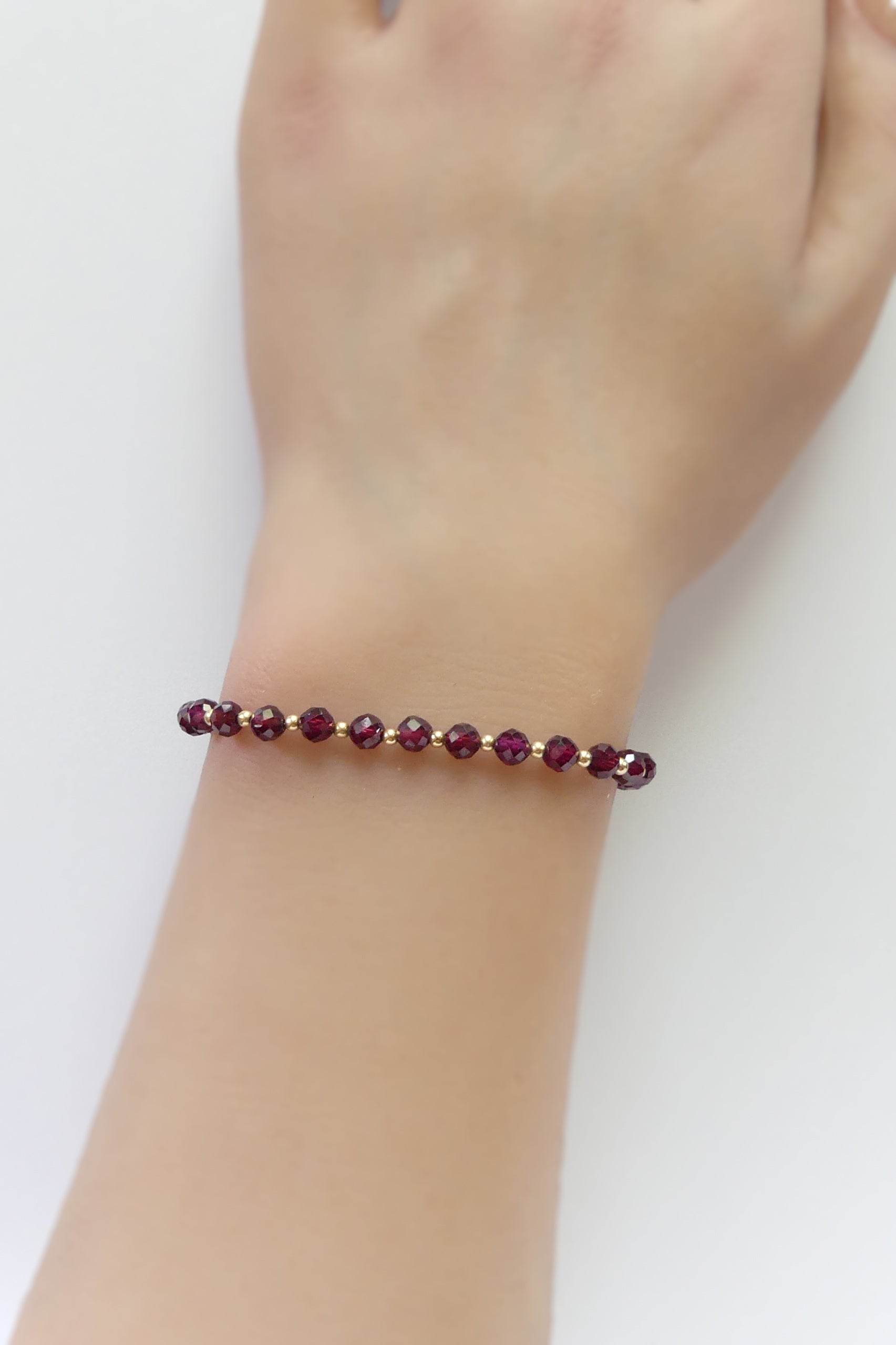 Red pyrope garnet bracelet made with 4mm faceted beads and 14k gold-filled clasp and accent spacers