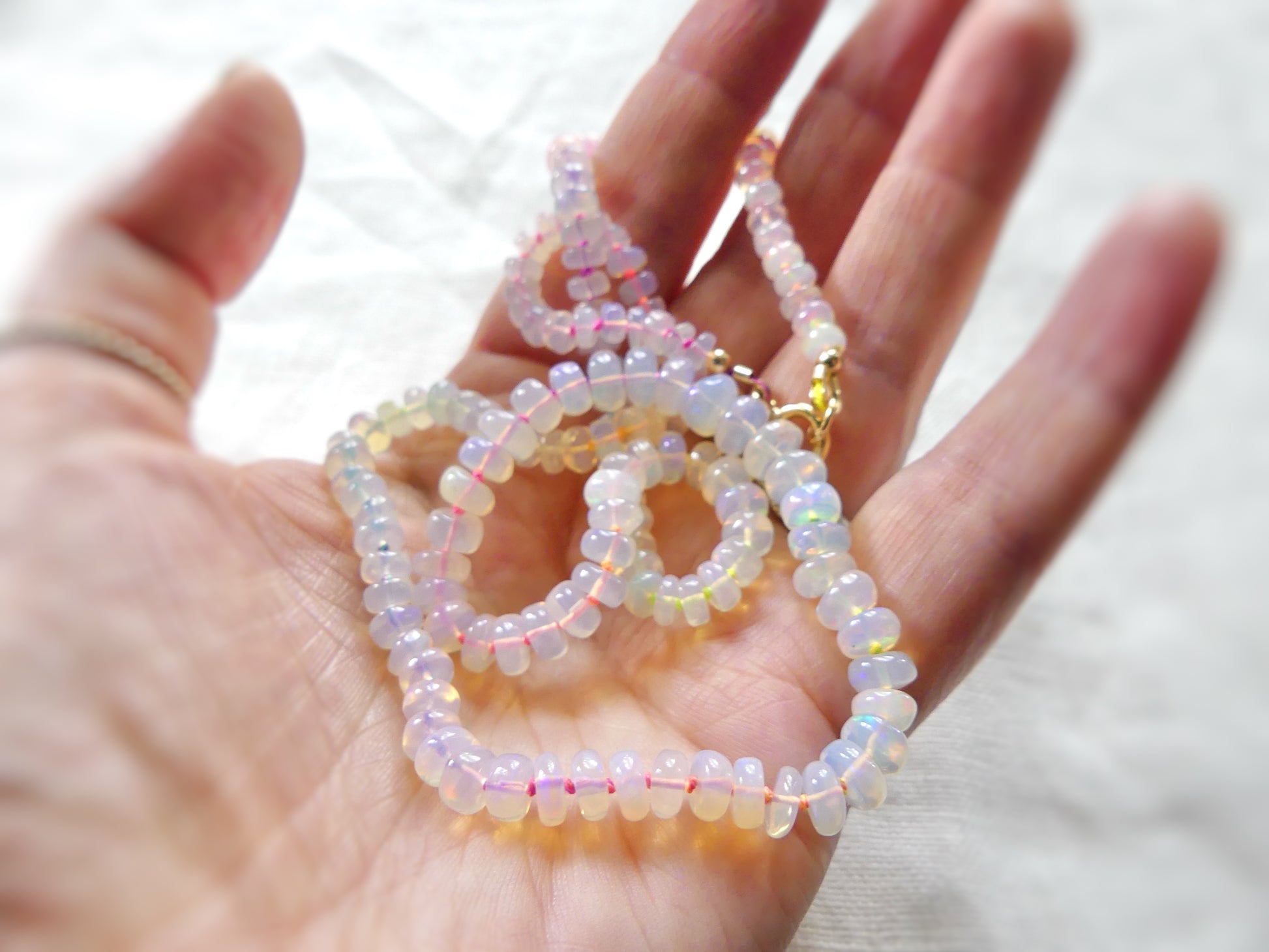 Ethiopian opal necklace with 5–7mm rondelles hand-knotted on neon rainbow silk, finished with a gold-filled clasp

